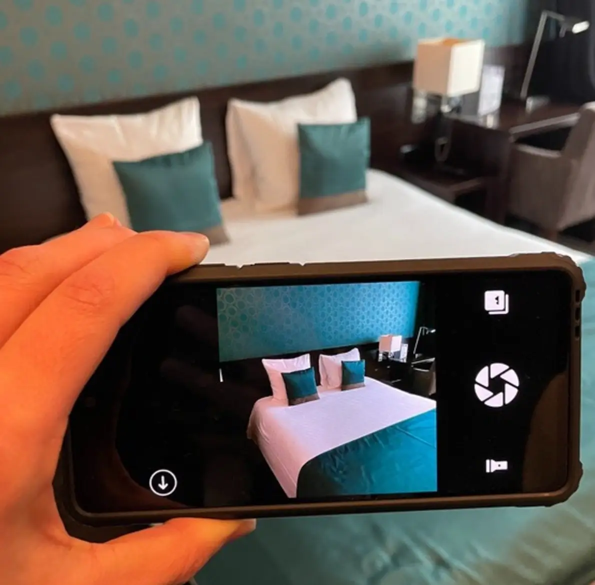 Housekeeper fotografeert een opgemaakt bed met de MiQa-app